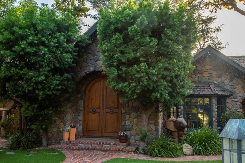 The stone front of the manor and its arched oak doors at The Enchanted Manor