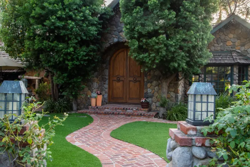 The arched oak doors, brick path and lanterns at the front of the manor at The Enchanted Manor