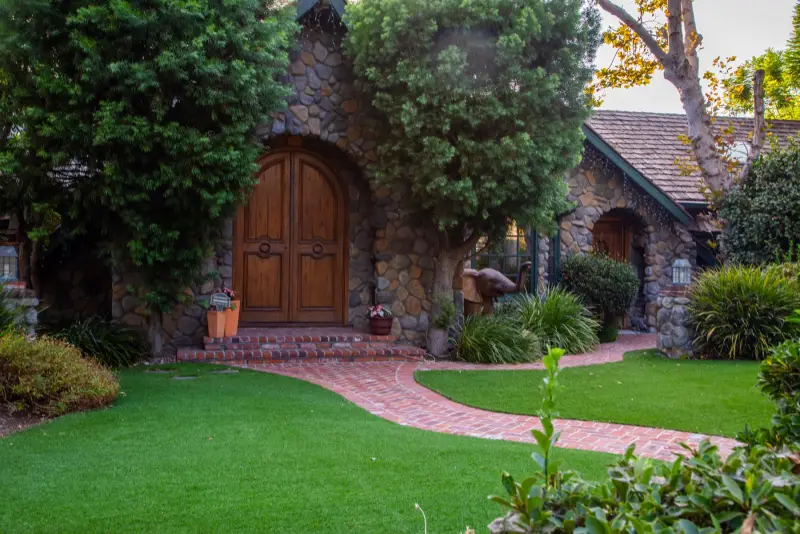 A curving brick path across the lawn to the arched front doors at The Enchanted Manor