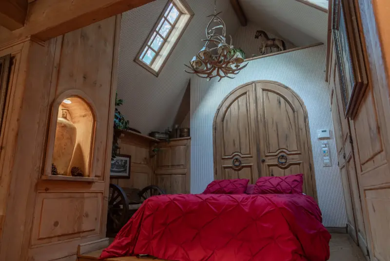 A bedroom with a skylight and carved arched doors at The Enchanted Manor
