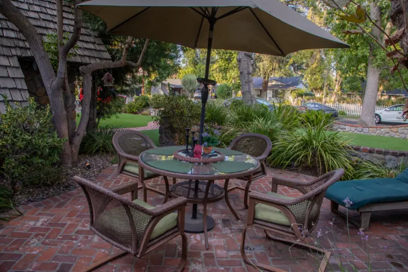 Patio dining under an umbrella in the front courtyard at The Enchanted Manor