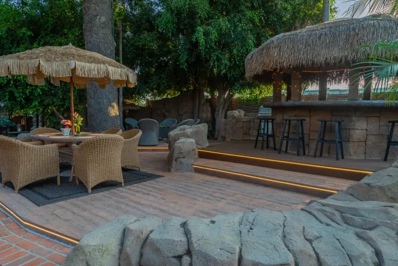 The lit deck, dining set and gazebo bar at The Enchanted Manor