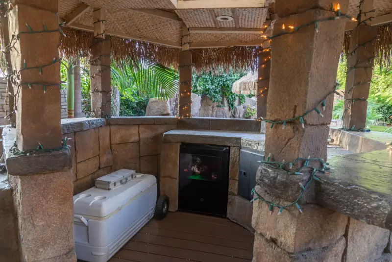 Inside the gazebo bar: refrigerator and serving counter at The Enchanted Manor