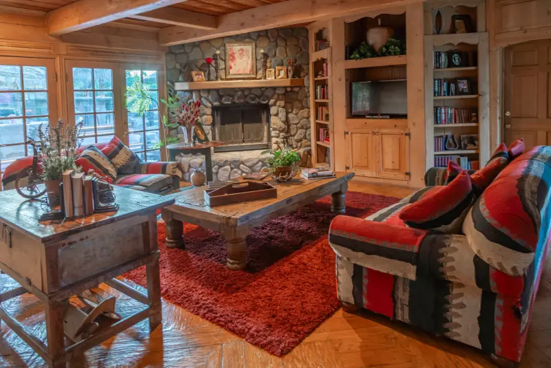 The Great Room's river-rock fireplace and bookshelves at The Enchanted Manor