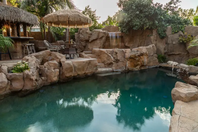 Rock waterfalls tumbling into the grotto pool at The Enchanted Manor
