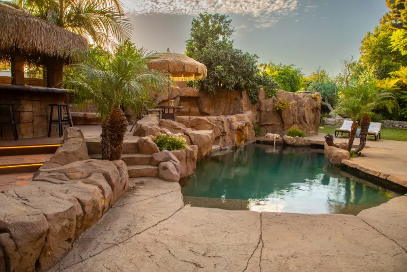 The saltwater grotto pool framed by rockwork and palms at The Enchanted Manor