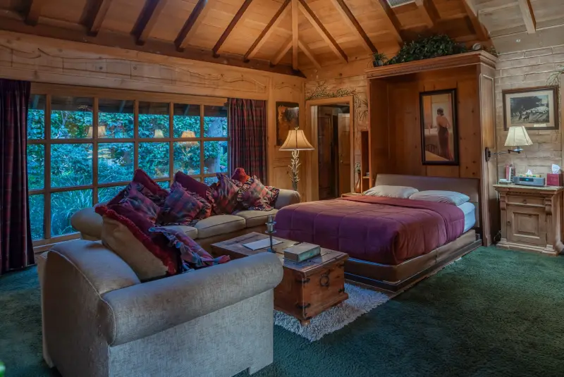 The Inn's sofas and bed beside the garden windows at The Enchanted Manor