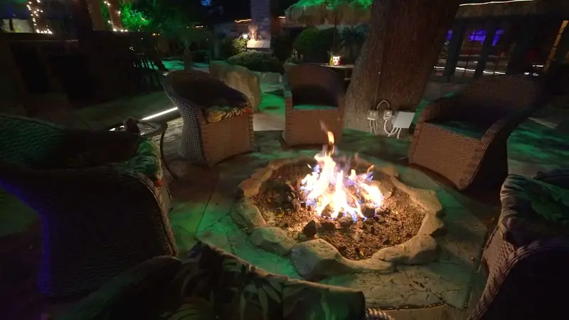 Wicker chairs around the fire pit at night at The Enchanted Manor