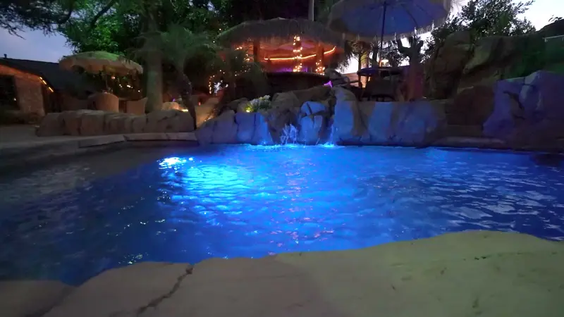 The grotto pool glowing blue after dark at The Enchanted Manor