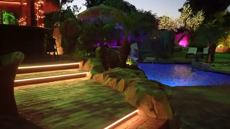 Lit deck steps down to the glowing pool at The Enchanted Manor