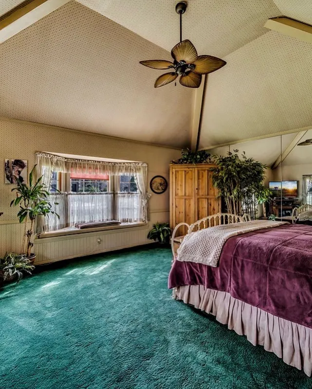 A bedroom with teal carpet at The Enchanted Manor