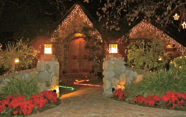 The front cottage strung with holiday lights at The Enchanted Manor