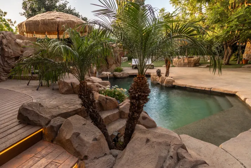 Palms growing from the rocks beside the pool at The Enchanted Manor