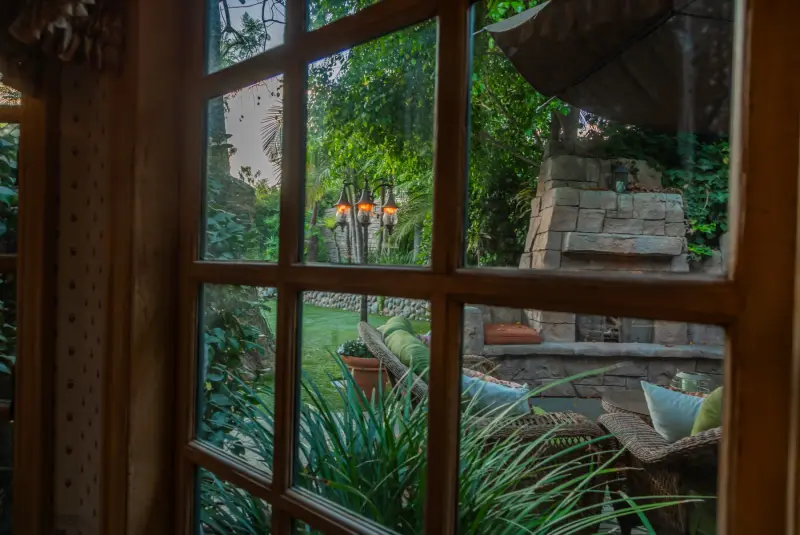 The outdoor fireplace patio seen through the breakfast room windows at The Enchanted Manor