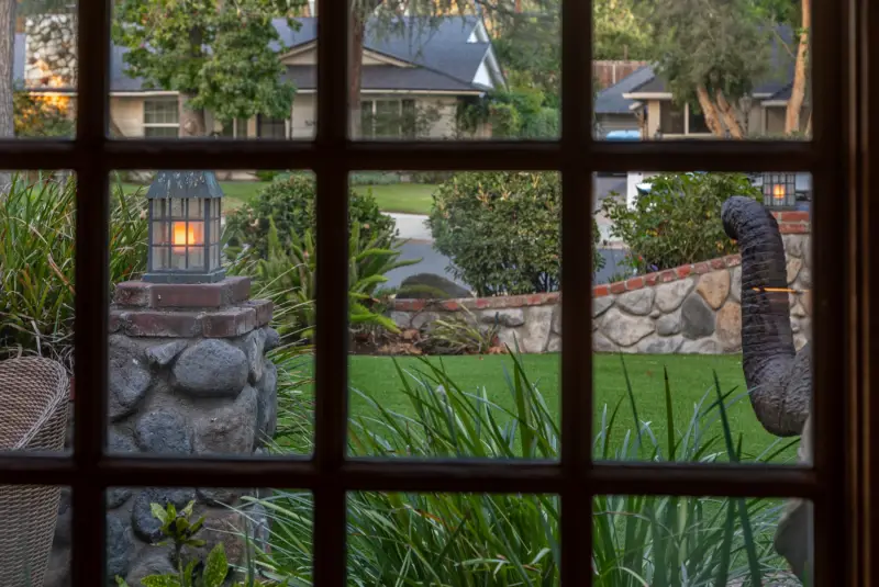 The lawn and lantern seen through a paned window at The Enchanted Manor